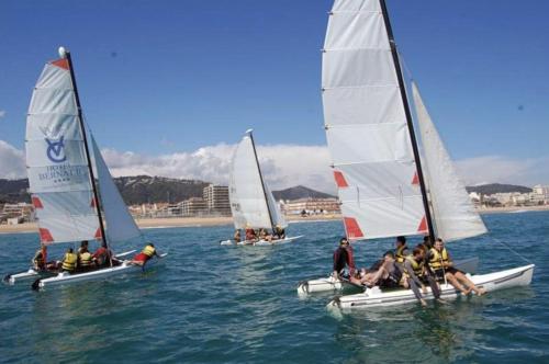 a group of people on small sailboats in the water at RCE Apartments Calella, brand new next to the beach. in Calella