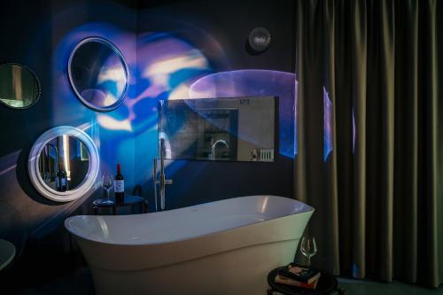 a bathroom with a tub and two mirrors at B&B La Castellina in Abbadia San Salvatore
