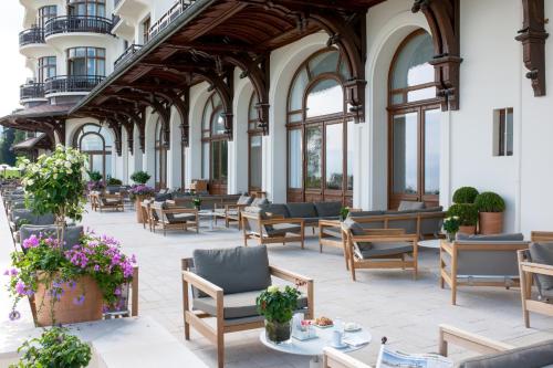 a large building with chairs and tables and windows at Hôtel Royal in Évian-les-Bains