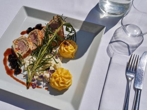 a white plate with food on a table at A-ROSA Ostseehotel Kühlungsborn in Kühlungsborn
