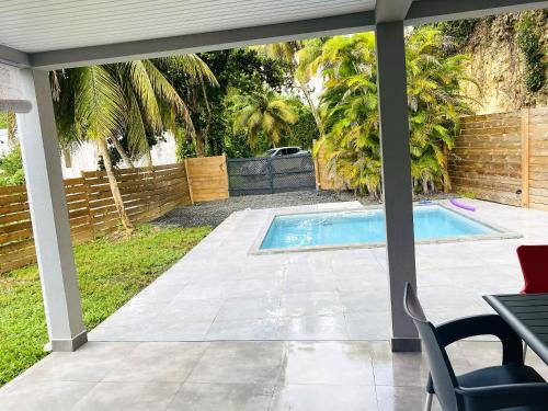 a patio with a swimming pool in a yard at Villa élégante Les Abymes, piscine in Baimbridge