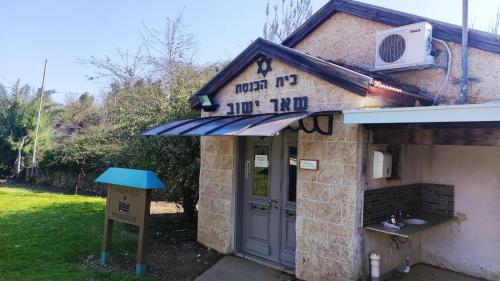 a small building with a sign in front of it at ירוק בטבע in Sheʼar Yashuv