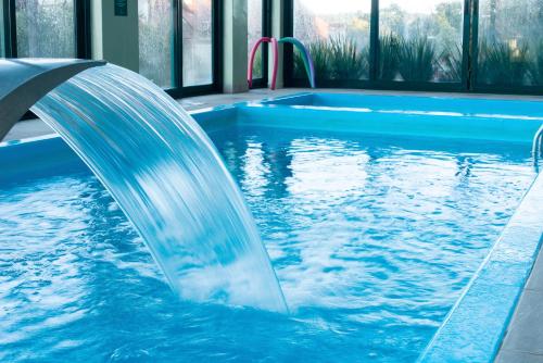 uma fonte de água numa piscina em Hotel Laghetto Toscana em Gramado