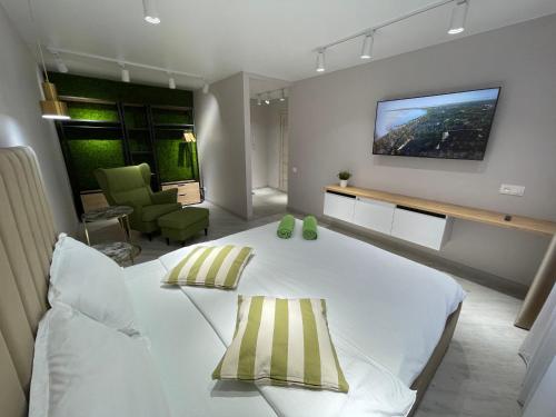 een slaapkamer met een groot wit bed en een televisie aan de muur bij “Same as Home apt”M.Zhusupa str. 284/1 in Pavlodar