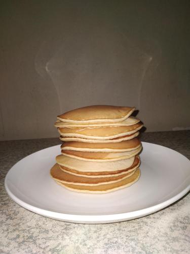 una pila de panqueques en un plato en una mesa en City Lodge Etosha, en Omuthiya