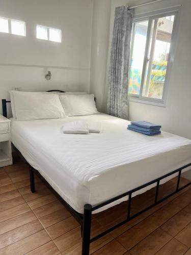 a large bed in a room with a window at Balai Tinay Guesthouse in Legazpi