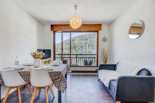 un salon avec un canapé bleu, une table et des chaises dans l'établissement Le Gentiana, à Saint-Nicolas-la-Chapelle