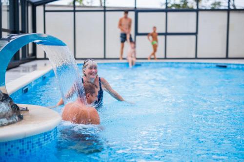 un jeune enfant jouant dans une piscine dans l'établissement Mobil Home XXL 4 chambres - Camping Le Brabois, à Villers-lès-Nancy