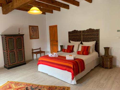 a bedroom with a large bed with red pillows at Brin de Cocagne in Fénols