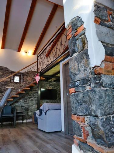 a room with a stone wall and a staircase at Homestead Zavadlal - Domačija Zavadlal in Komen