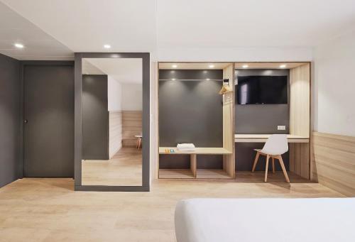a room with a mirror and a table and a chair at Hostal Lami in Esplugues de Llobregat