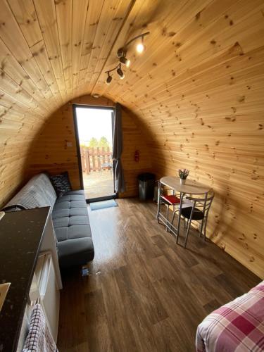 a living room with a couch and a table at Arisaig Pods in Arisaig