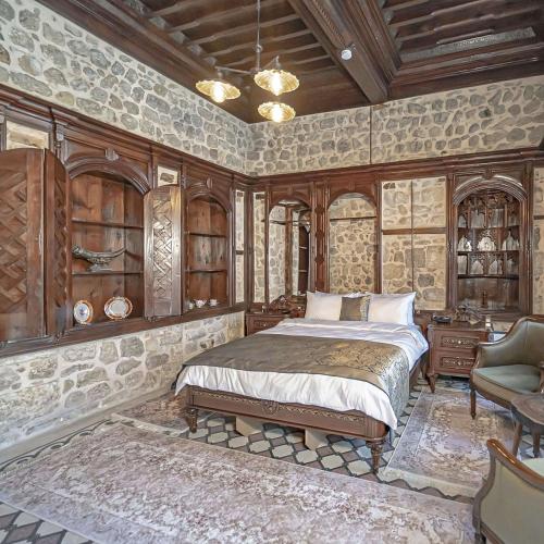 a bedroom with a bed and a couch and a chair at Konak Avula Boutique Hotel in Hatay