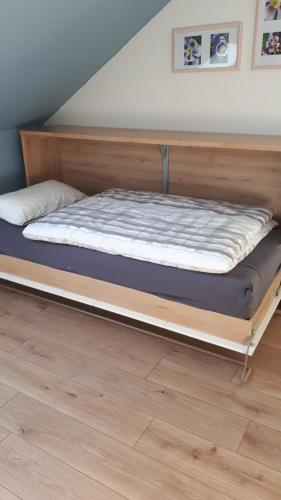 a bed with a wooden frame in a room at Ferienwohnung Am Hoppenberg in Brilon