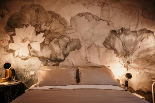 1 dormitorio con 1 cama con un mural de flores en la pared en B&B La Castellina, en Abbadia San Salvatore