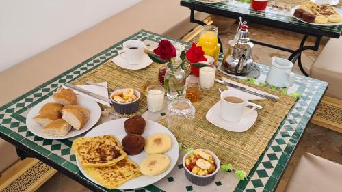 uma mesa coberta com pratos de pequeno-almoço e café em Riad Alizé em Marrakech