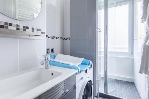a bathroom with a washing machine and a sink at L'Escale Marine in Dunkerque