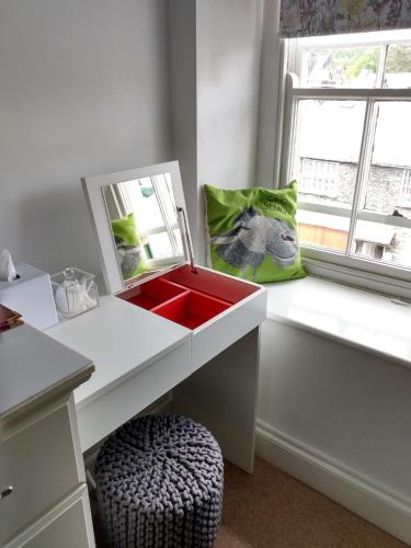 a white desk with a red sink and a window at The Lakes B and B in Ambleside
