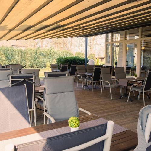 an outdoor patio with chairs and tables and windows at Hotel Saltenhof in Hörstel