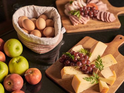 einen Tisch mit Teller mit Käse und Obst in der Unterkunft aja Strandhotel Bansin in Bansin