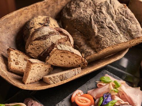 eine Holzschüssel gefüllt mit Brot und Brotscheiben in der Unterkunft aja Strandhotel Bansin in Bansin