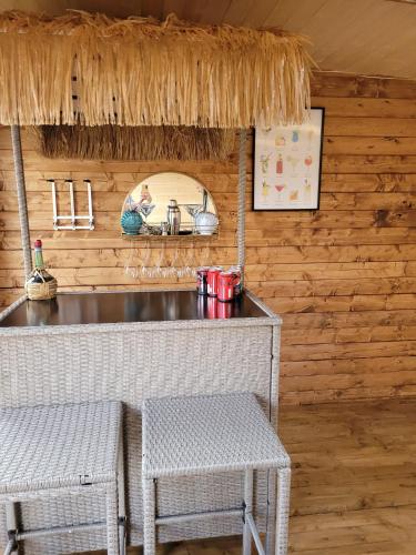 a kitchen with a counter and two stools in a cabin at Dolphin House in Preesall