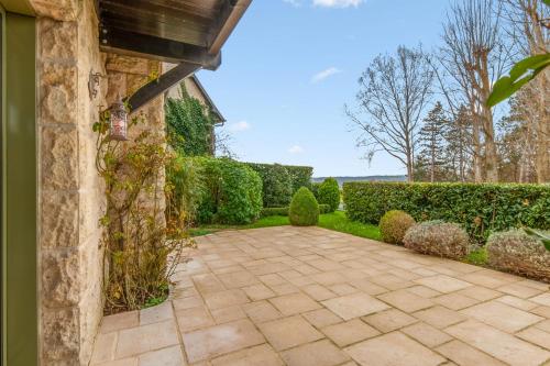 une passerelle en pierre devant une maison avec haies dans l'établissement Appartement Amirauté - Welkeys, à Tourgéville