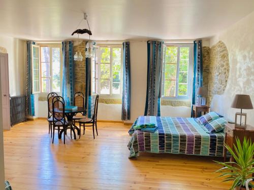 a bedroom with a bed and a table and chairs at Chambres d'Hôtes Domaine Saint-Joly in Lasbordes