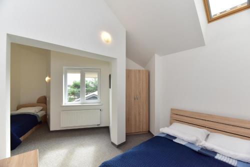 a bedroom with two beds and a window at Vila GULBĖS TAKAS in Šventoji