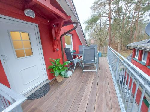 a porch of a red house with a table and chairs at Ferienwohnung Bernstein in Dierhagen