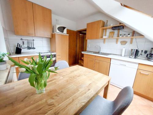 a kitchen with a wooden table with a vase of flowers on it at Ferienwohnung Bernstein in Dierhagen