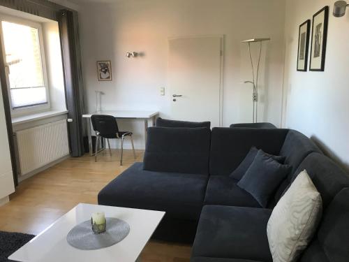 a living room with a blue couch and a table at Ferienwohnung Aronia in Warlow