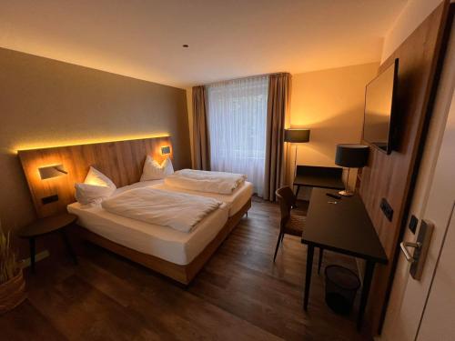 a hotel room with a bed and a desk at Hotel-Restaurant Amadeus in Hannover