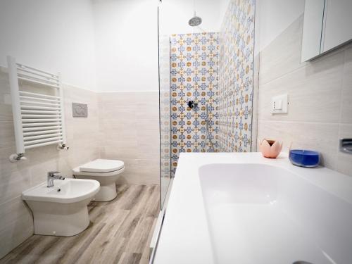 y baño con bañera, aseo y lavamanos. en DIMORA SOTTORIPA 24 DI FRONTE ALL’ACQUARIO - GENOVABNB IT, en Génova