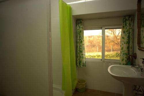 ein Badezimmer mit einem grünen Duschvorhang und einem Waschbecken in der Unterkunft Taia Casa Rural 2 **. Alojamiento y actividades in Merida
