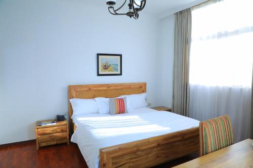 a bedroom with a bed and a blue wall at Victoria Hotel Apartment in Addis Ababa
