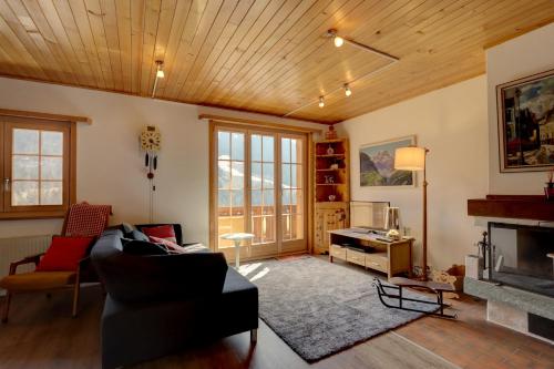 un soggiorno con divano e camino di Appartement Le Roc a Gstaad