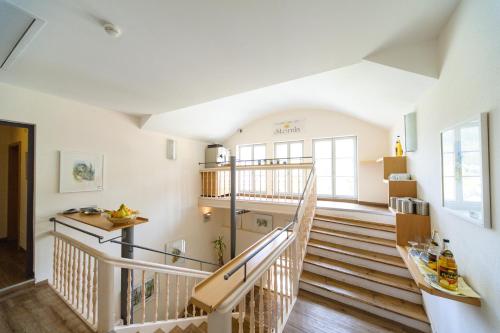 a staircase in a house with white walls and wooden floors at Akzent Hotel Goldner Stern in Muggendorf