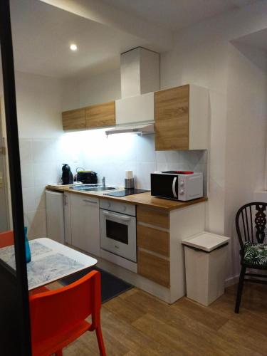 une cuisine avec une cuisinière et un micro-ondes dans l'établissement Studio Top, à Perros-Guirec