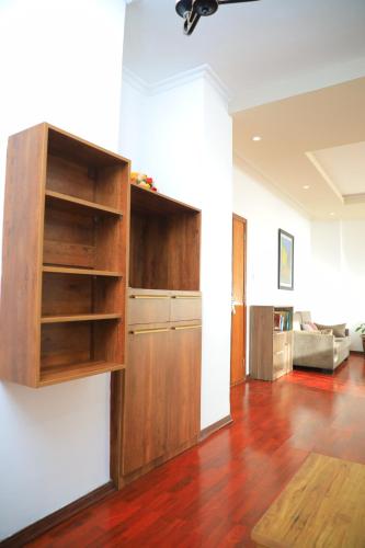 a kitchen with wooden shelves and a living room at Victoria Hotel Apartment in Addis Ababa