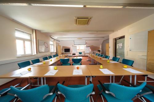 a classroom with tables and chairs in a classroom at Akzent Hotel Goldner Stern in Muggendorf
