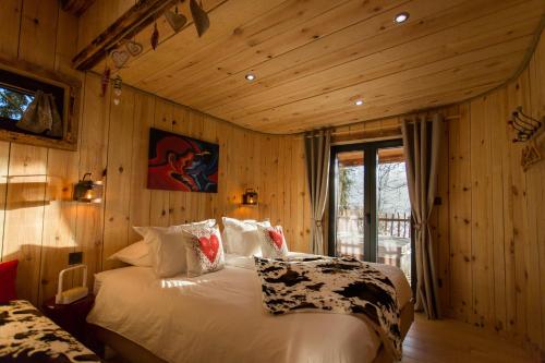 una camera con un letto in una stanza con pareti in legno di Domaine de l'Authentique Cabanes dans les arbres a Fournet-Blancheroche