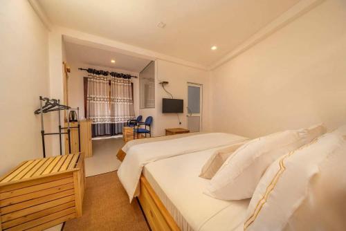 a hotel room with two beds and a television at 3 Arch Resort Ella in Ella