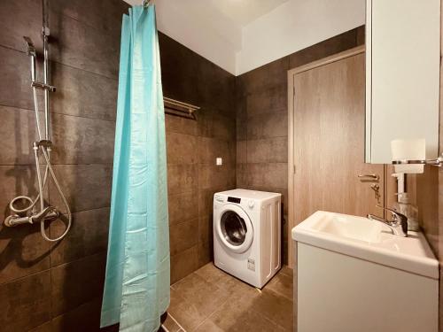 a bathroom with a washing machine and a sink at Diamond Apartment in Athens