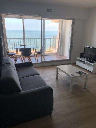 a living room with a couch and a view of the ocean at Studio face mer in Saint-Michel-Chef-Chef