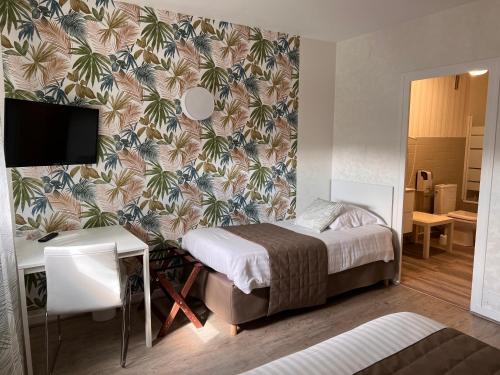 ein Schlafzimmer mit einem Bett und einer Tapete in der Unterkunft Hotel Alpes Cevennes in Guilherand