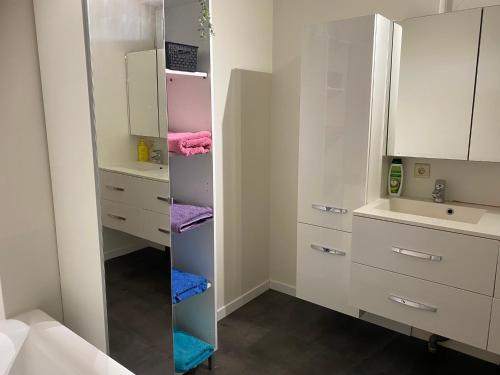 a bathroom with white cabinets and a mirror at Modern Spanish Hacienda - 10km from the coast in Ichtegem