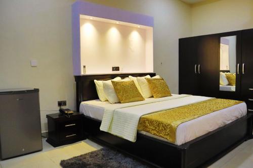 a bedroom with a large bed with gold pillows at Labev Hotel in Kumasi
