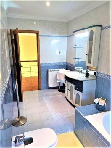 a bathroom with a sink and a toilet and a mirror at Anjos’home in Viana do Castelo