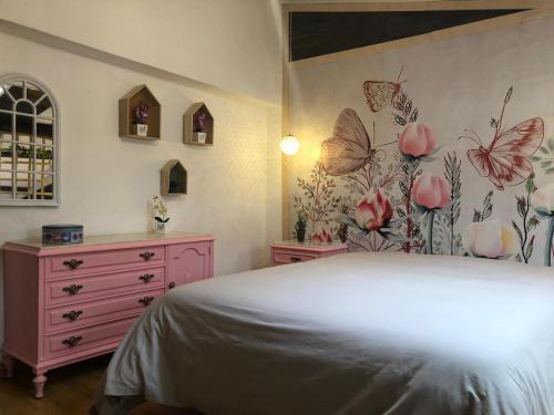 サント・ドミンゴ・デ・ラ・カルサーダにあるLa casita de mi abuelaのベッドルーム1室(ベッド1台付)、壁に蝶が飾られたドレッサーが備わります。